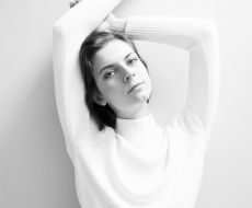 grayscale photography of woman leaning on wall